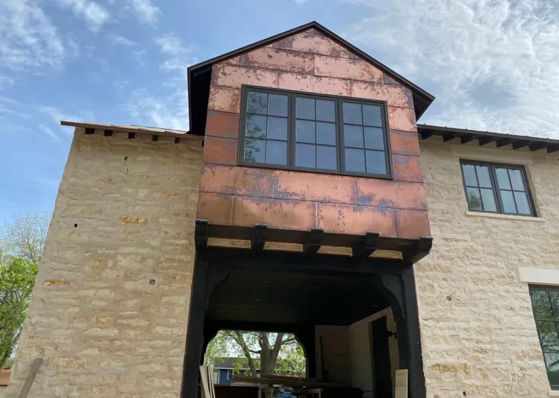 Copper metal panel facade on a stone building for Skylight Installation in Sauk Rapids